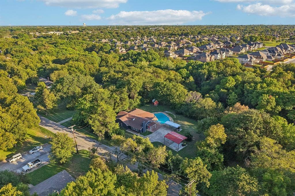 500 Spinner Road, DeSoto, TX 75115 Residence featuring a private swimming pool, extensive tree canopy, and a detached carport structure