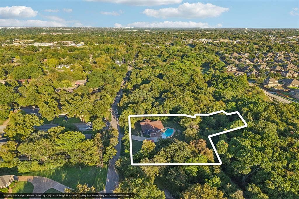 500 Spinner Road, DeSoto, TX 75115 Expansive lot featuring mature trees, a swimming pool, and a residential structure with an attached garage