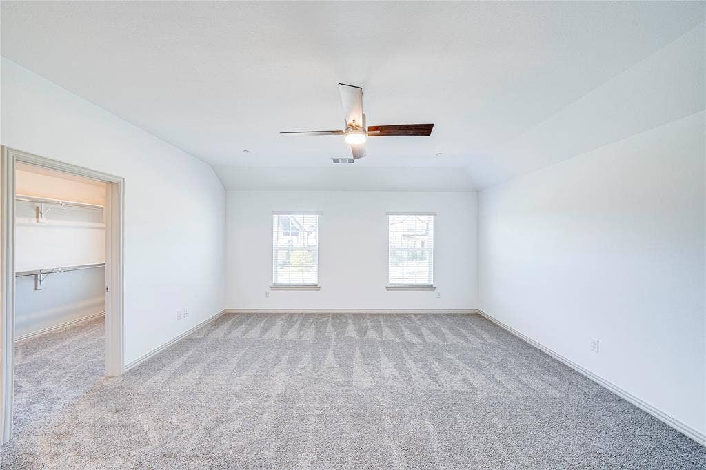 8888 Samara Street, Frisco, TX 75035 Spacious room featuring vaulted ceilings, light gray carpeting, two windows, and a ceiling fan