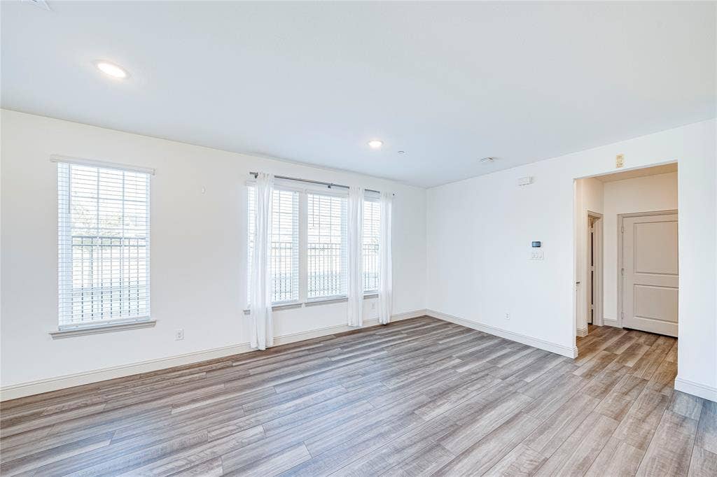 8888 Samara Street, Frisco, TX 75035 Spacious room featuring wood-finish flooring, recessed lighting, and multiple windows with blinds
