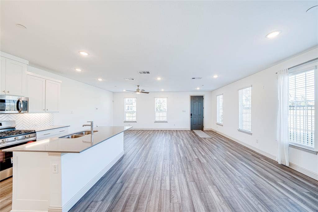 8888 Samara Street, Frisco, TX 75035 Expansive open-concept living area featuring wood-finish flooring, recessed lighting, and a ceiling fan
