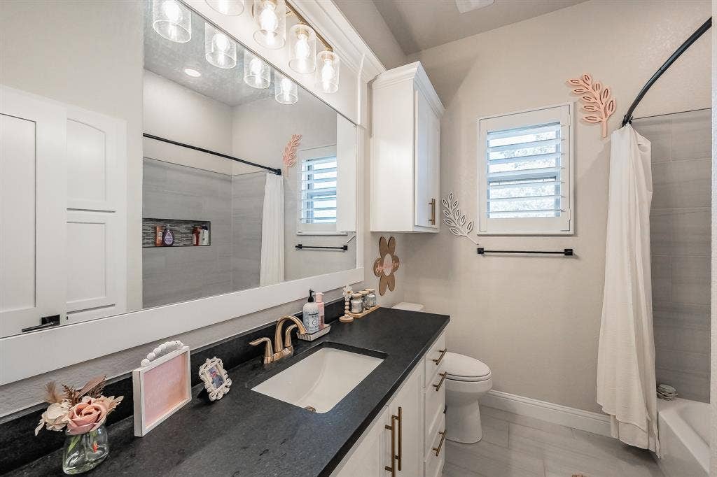 Hall bath with granite countertop & storage behind the door.