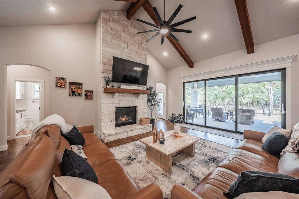 Soaring 16-ft vaulted ceilings, stone gas-log fireplace, and view of the oversized patio through the 8x12 slider back doors!