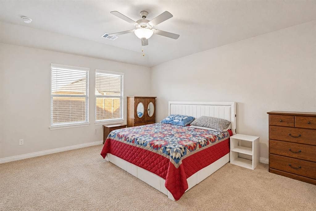 753 Poppy Lane, Lavon, TX 75166 Neutral-toned room featuring high ceilings, wall-to-wall carpeting, a multi-blade ceiling fan with integrated lighting, and dual windows equipped with horizontal blinds