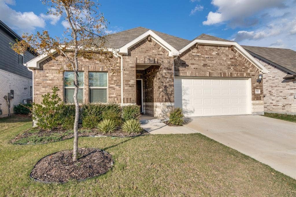 753 Poppy Lane, Lavon, TX 75166 Brick exterior featuring a gabled roofline, two-car garage, concrete driveway, and landscaped front lawn