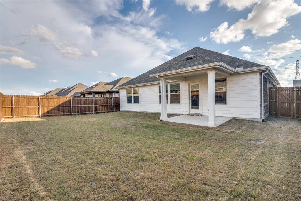 753 Poppy Lane, Lavon, TX 75166 Rear exterior featuring horizontal lap siding, a covered patio with columns, and a perimeter wood fence