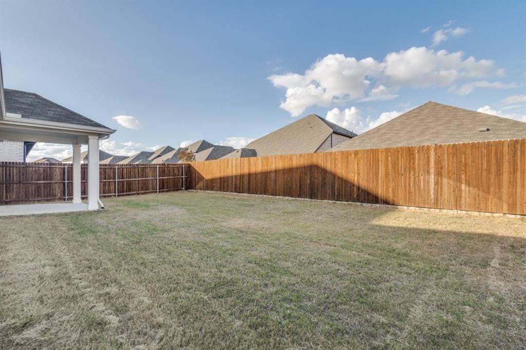753 Poppy Lane, Lavon, TX 75166 Backyard featuring a concrete patio, covered porch area with square columns, and wooden privacy fencing