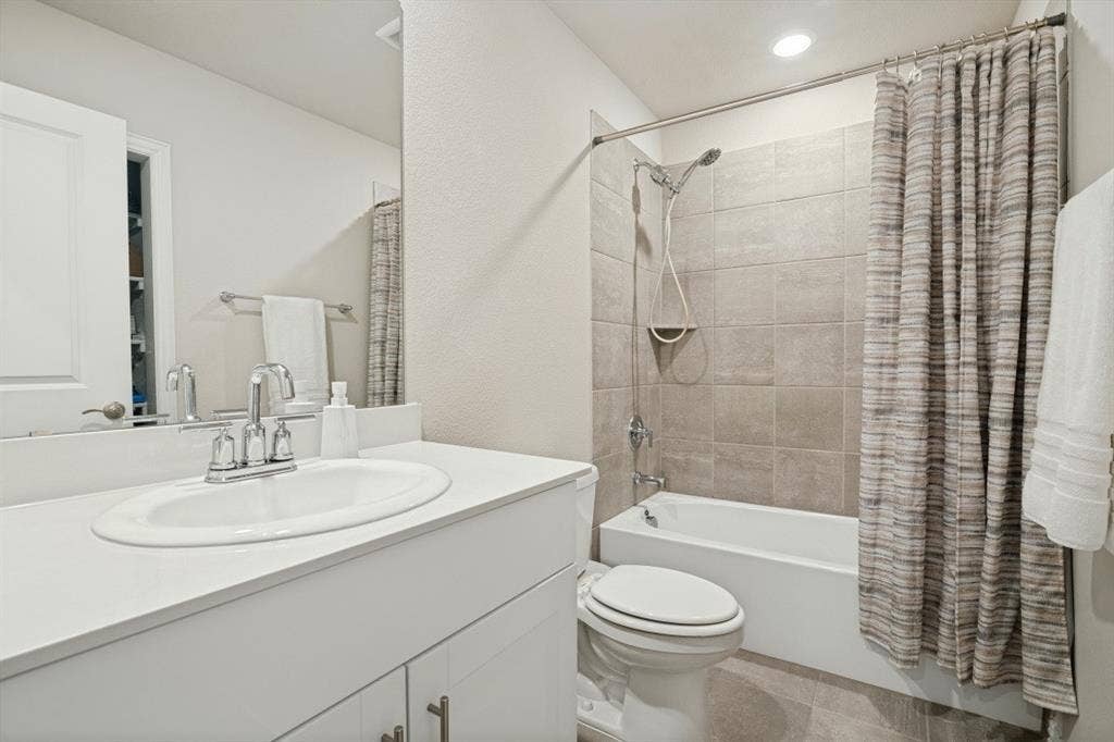 753 Poppy Lane, Lavon, TX 75166 Bathroom featuring a vanity with a solid-surface countertop, an integrated sink, a full-width mirror, a tub-shower combination with tile surround, and a handheld shower fixture