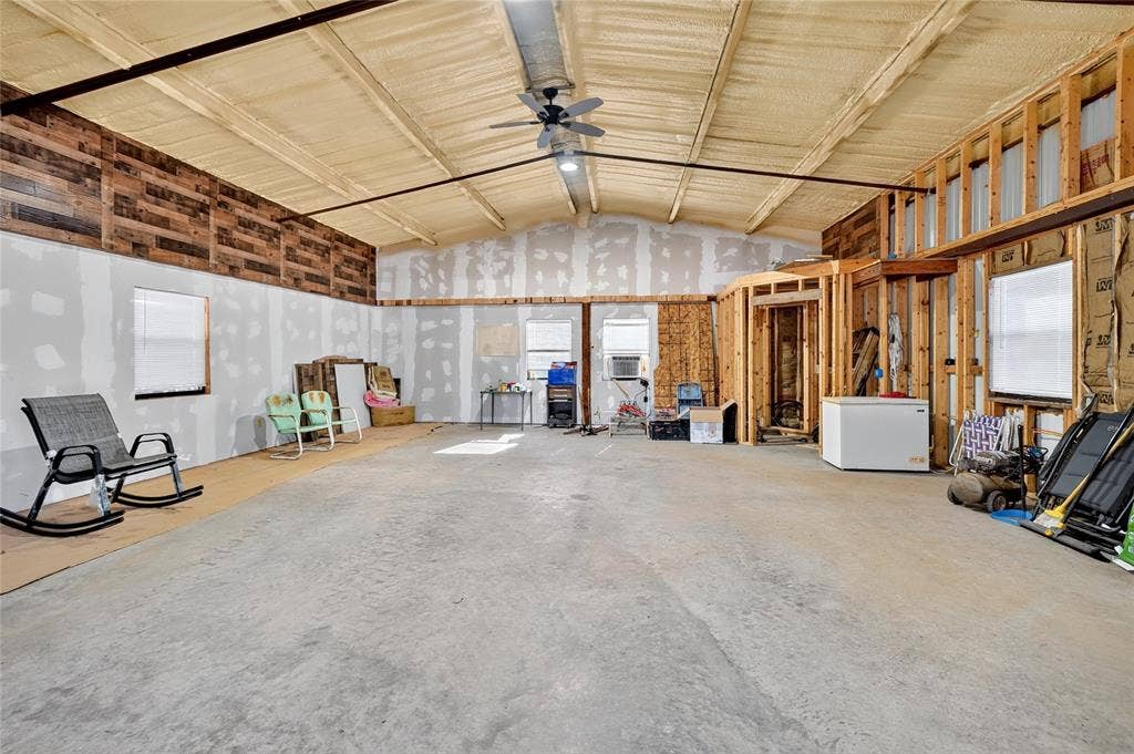 Interior structure with exposed framing, high ceilings, and a concrete floor