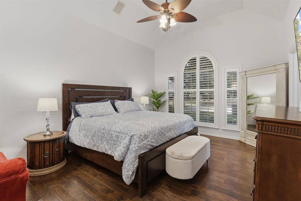5104 Teddington Park Drive, Plano, TX 75023 Vaulted ceiling with a ceiling fan, hardwood flooring, arched window with plantation shutters, and recessed lighting
