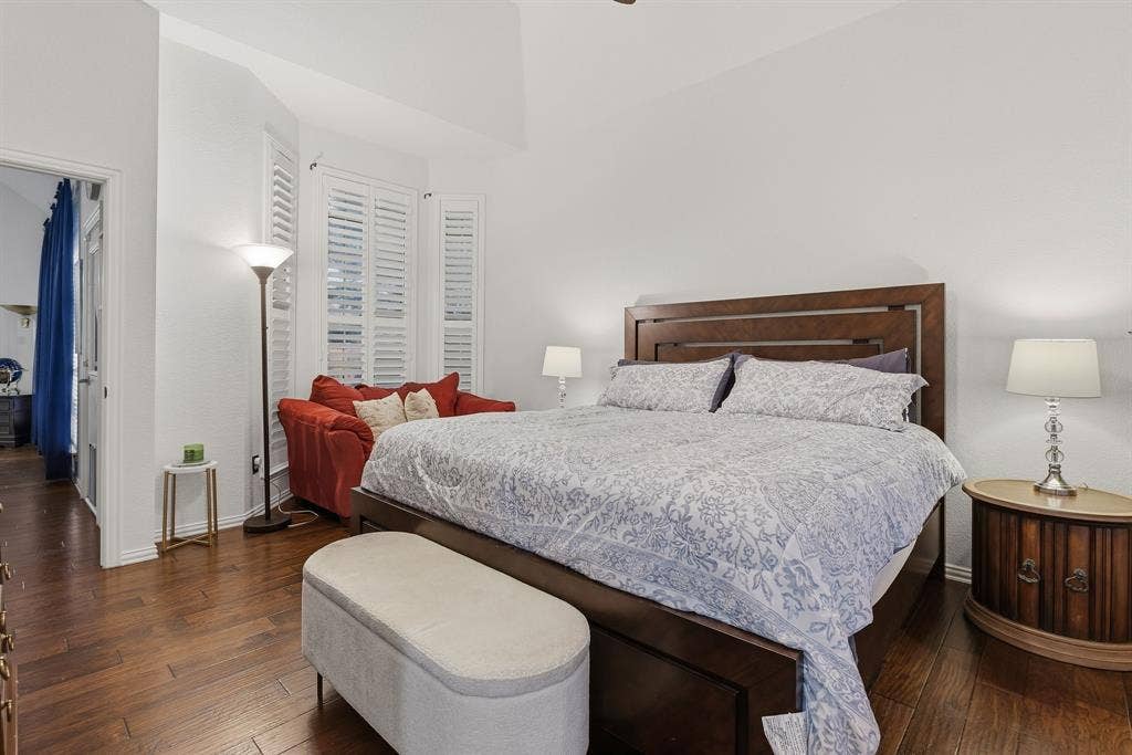 5104 Teddington Park Drive, Plano, TX 75023 Wood-finish flooring, white walls, angled ceiling, bay window with plantation shutters, and a doorway