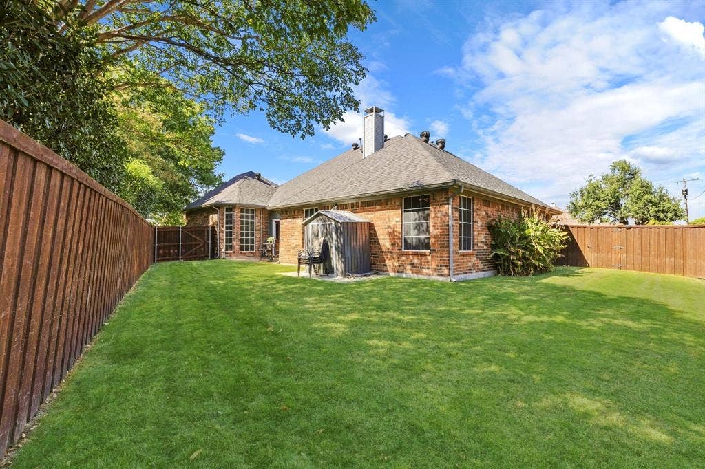 5104 Teddington Park Drive, Plano, TX 75023 Expansive backyard with a manicured lawn, full brick exterior, and a privacy fence