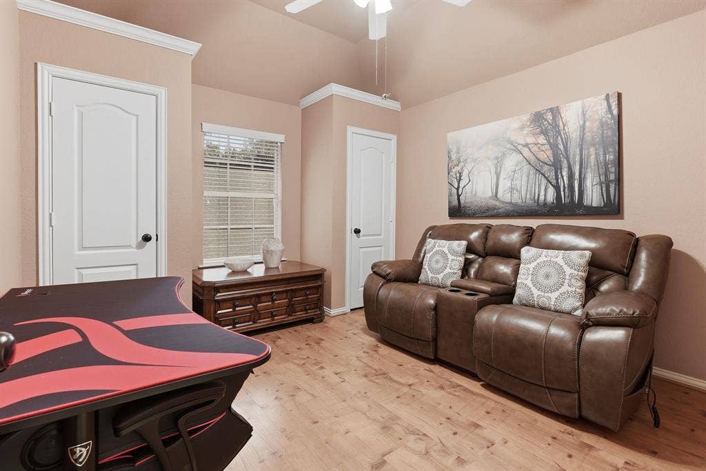 5104 Teddington Park Drive, Plano, TX 75023 Vaulted ceiling, wood-finish flooring, white paneled doors, crown molding, and a ceiling fan