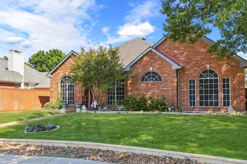 5104 Teddington Park Drive, Plano, TX 75023 Brick facade with arched windows, gabled roof, and mature landscaping