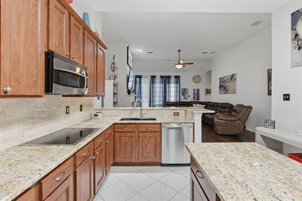 5104 Teddington Park Drive, Plano, TX 75023 Kitchen featuring wood cabinetry, light-toned countertops, a built-in microwave, and stainless steel appliances