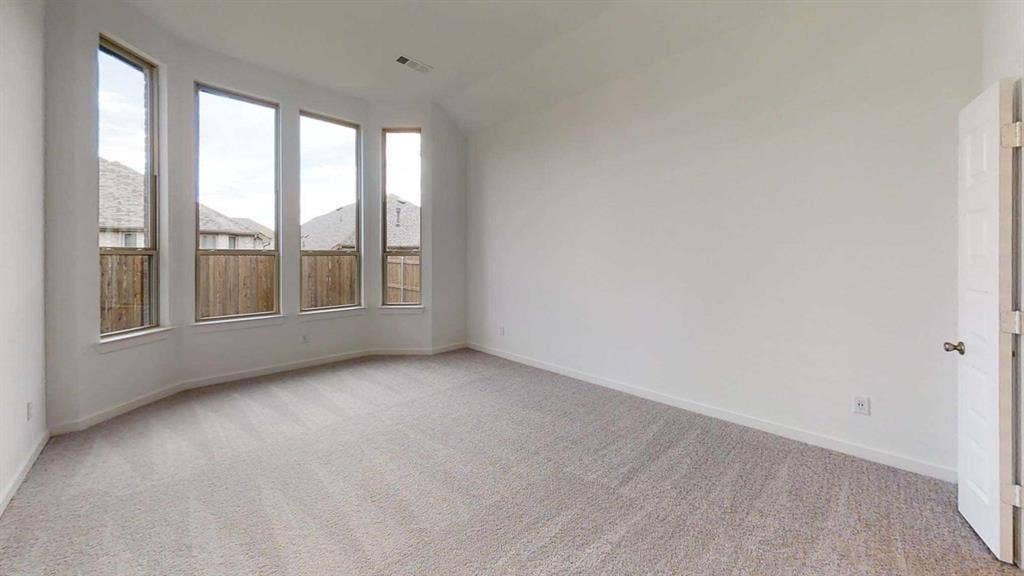 1553 Wyler Drive, Forney, TX 75126 Expansive room featuring a bay window with multiple vertical panes, light-colored carpeting, a neutral wall finish, and a paneled door