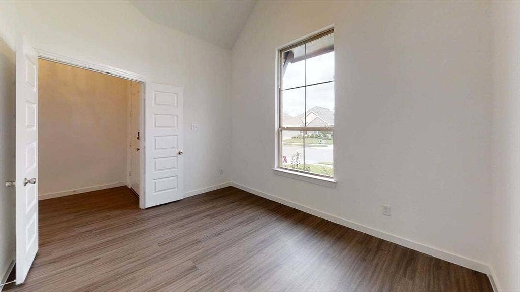 1553 Wyler Drive, Forney, TX 75126 Vaulted ceiling, wood-finish flooring, white walls, and a large window