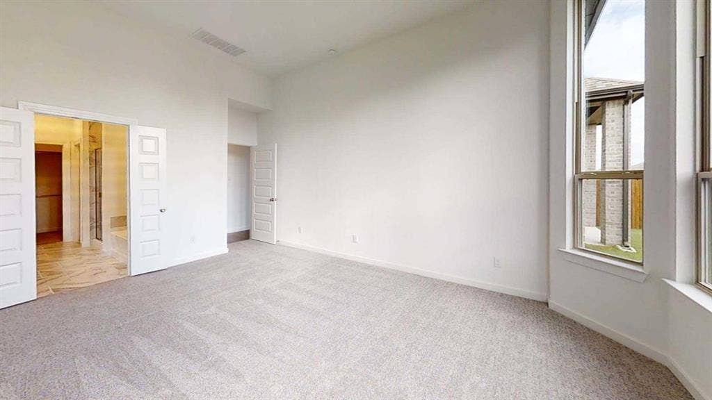 1553 Wyler Drive, Forney, TX 75126 Spacious room featuring light-toned carpeting and tall windows