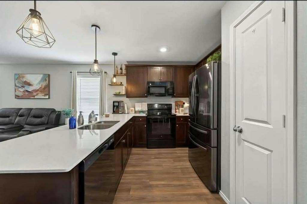 554 Deerfern Drive, Princeton, TX 75407 Kitchen featuring dark wood-finish cabinetry, black appliances, white countertops, and wood-finish flooring