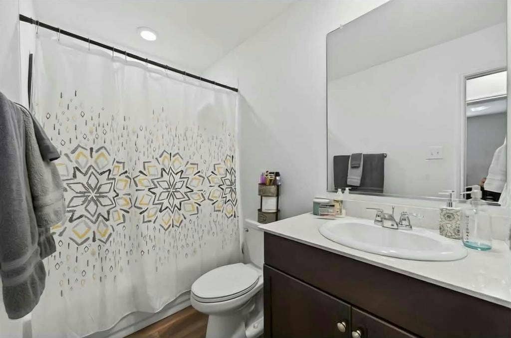 554 Deerfern Drive, Princeton, TX 75407 Recessed ceiling lighting, wood-finish flooring, dark wood-finish vanity with chrome hardware, integrated rectangular sink, and a large wall-mounted mirror