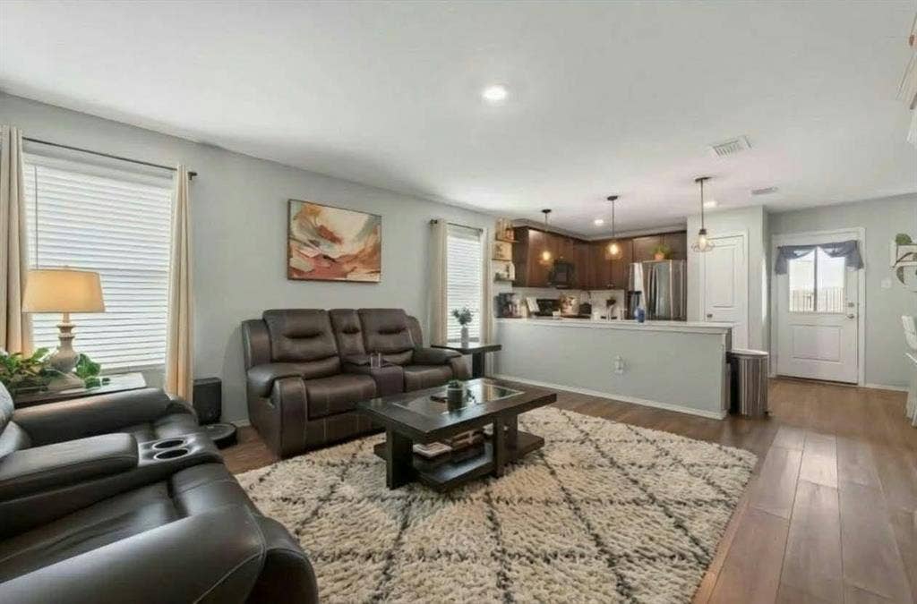 554 Deerfern Drive, Princeton, TX 75407 Open-concept living area featuring wood-finish flooring, recessed lighting, and a kitchen with dark wood cabinetry and stainless steel appliances