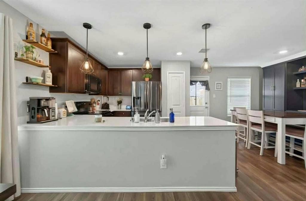 554 Deerfern Drive, Princeton, TX 75407 Kitchen featuring dark wood-finish cabinetry, white countertops, three pendant lights, recessed lighting, and wood-finish flooring
