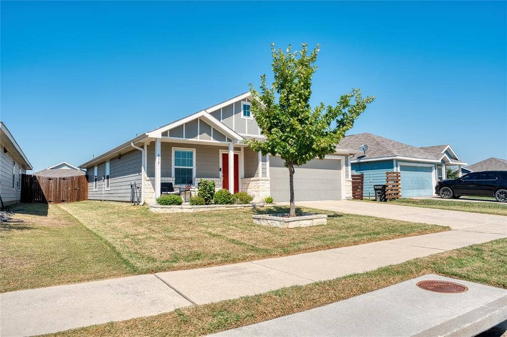 554 Deerfern Drive, Princeton, TX 75407 Single-story residence featuring a gray exterior with white trim, a red front door, and an attached two-car garage