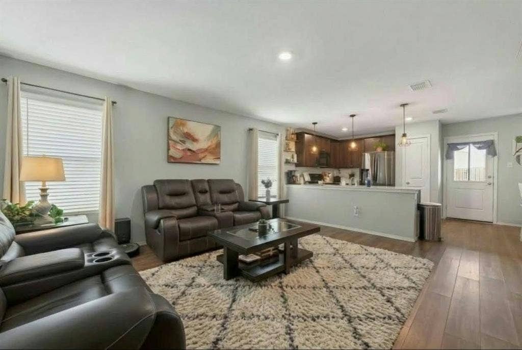 554 Deerfern Drive, Princeton, TX 75407 Open-concept living area with wood-finish flooring, recessed lighting, and a kitchen featuring dark wood cabinetry and stainless steel appliances