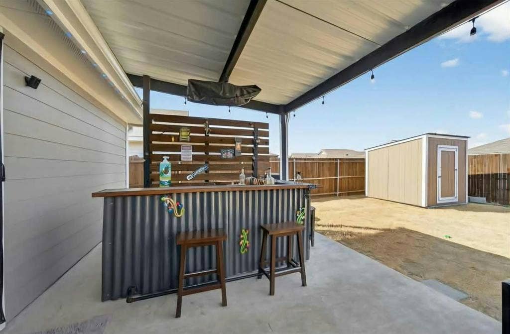 554 Deerfern Drive, Princeton, TX 75407 Covered patio featuring a built-in bar with corrugated metal and wood-finish accents