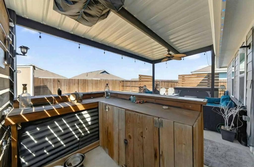 554 Deerfern Drive, Princeton, TX 75407 Covered patio with a built-in wood bar, metal roofing, outdoor ceiling fan, and string lighting