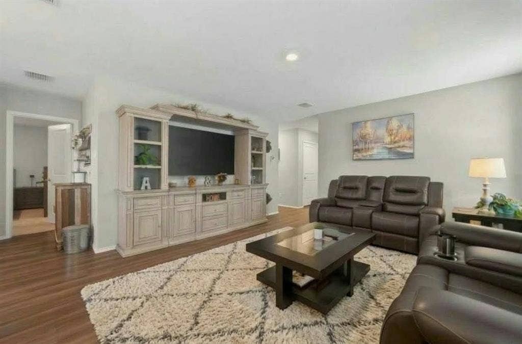 554 Deerfern Drive, Princeton, TX 75407 Wood-finish flooring throughout, light gray wall color, recessed ceiling lighting, built-in entertainment center with display shelving
