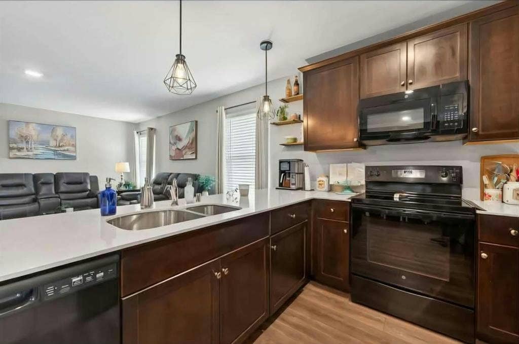 554 Deerfern Drive, Princeton, TX 75407 Kitchen featuring wood-finish flooring, dark wood cabinetry, white countertops, and stainless steel sink