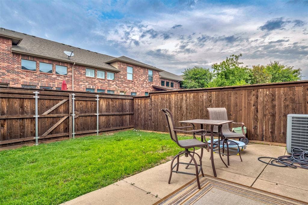 1040 Lucy Lane, Allen, TX 75013 Expansive wood privacy fencing surrounds a green lawn and concrete patio