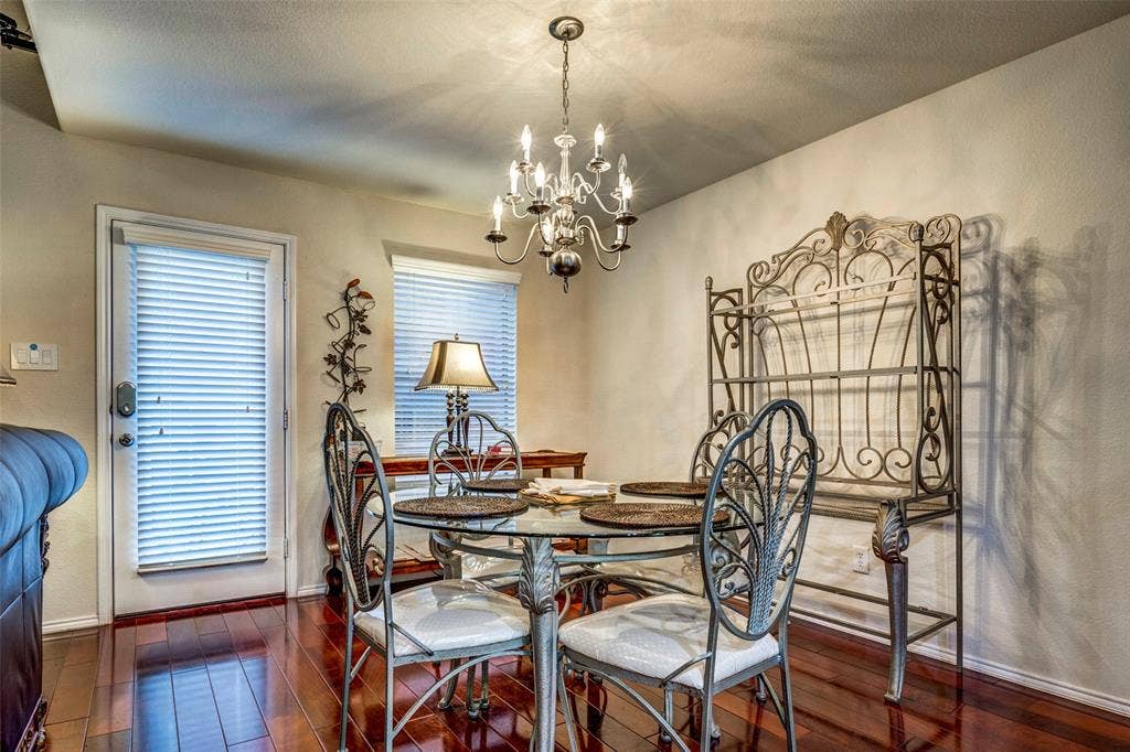 1040 Lucy Lane, Allen, TX 75013 Elegant dining room showcasing a decorative wrought iron chandelier, hardwood flooring, and ornate metal dining chairs with upholstered seats