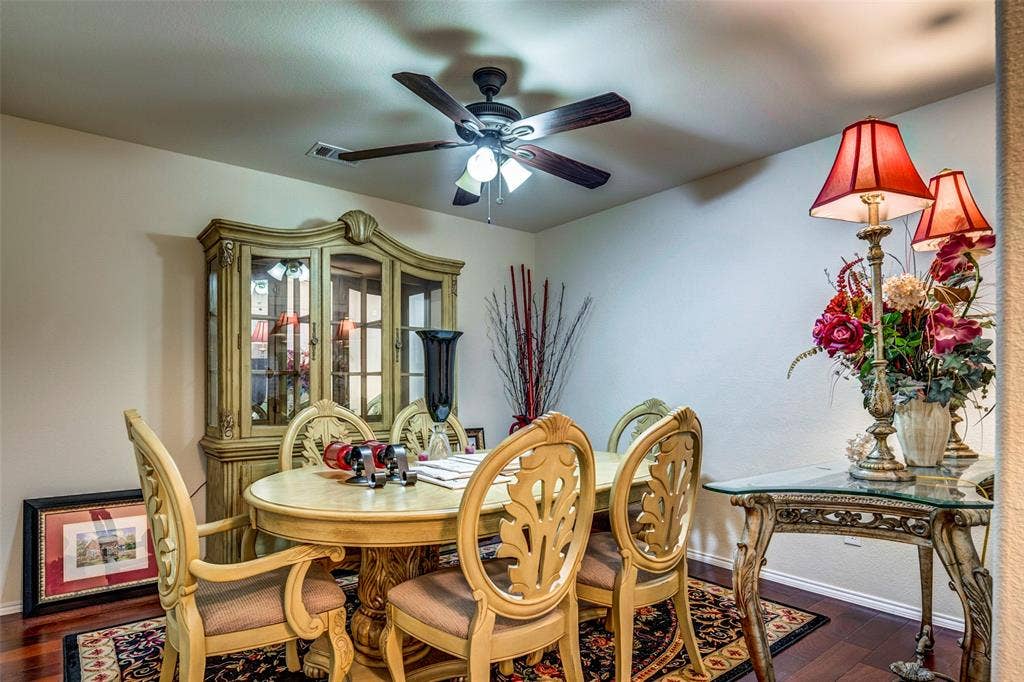 1040 Lucy Lane, Allen, TX 75013 Wood-finish flooring, ceiling fan, built-in display cabinet with glass panels, and wall-mounted light fixtures