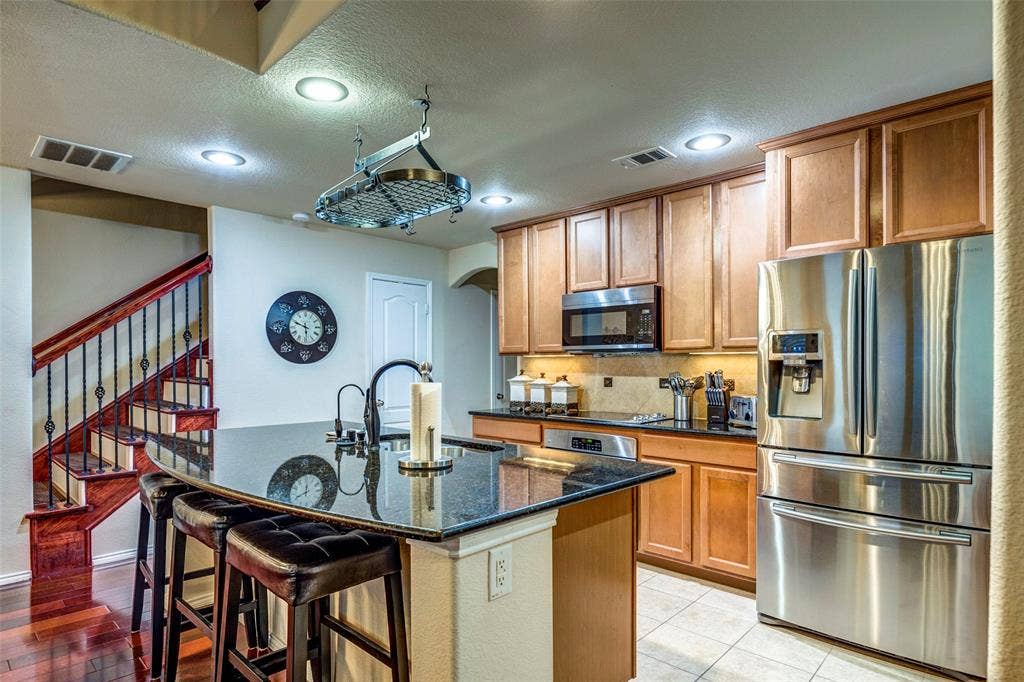 1040 Lucy Lane, Allen, TX 75013 Gourmet kitchen with stainless steel appliances, granite countertops, wood cabinetry, and recessed lighting