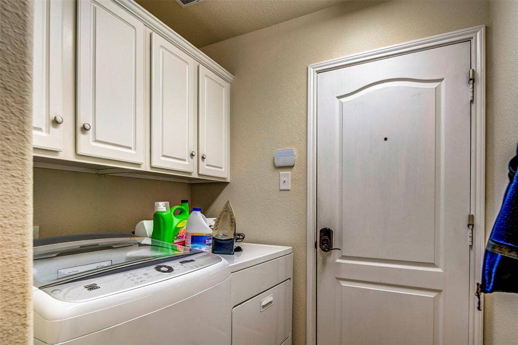 1040 Lucy Lane, Allen, TX 75013 Built-in white cabinetry with chrome hardware, white paneled door with dark hardware, and a light wall color
