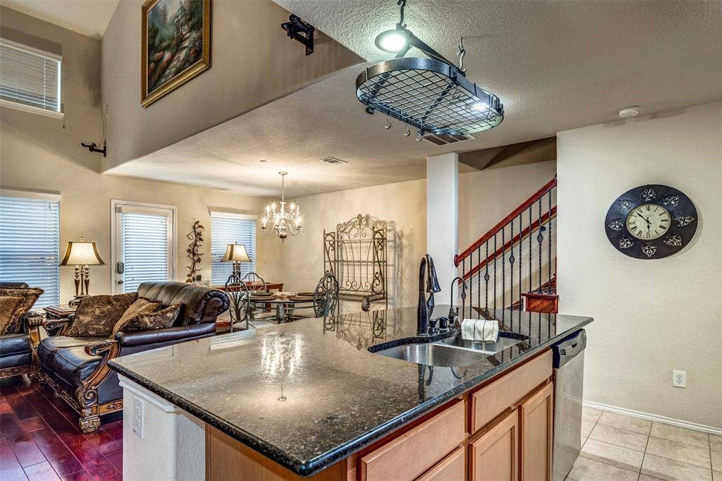 1040 Lucy Lane, Allen, TX 75013 Kitchen island with dark granite countertop and stainless steel sink