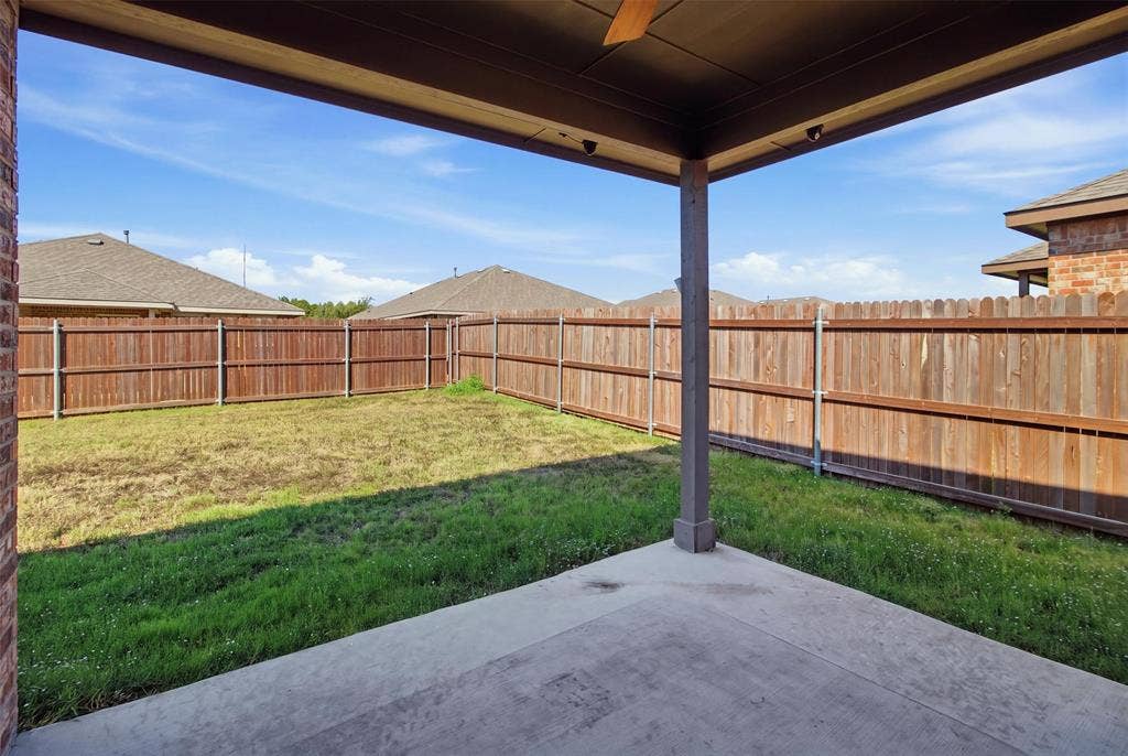 2513 Foules Drive, Glenn Heights, TX 75154 Covered patio with concrete flooring, wood fence enclosure, and a grass lawn area
