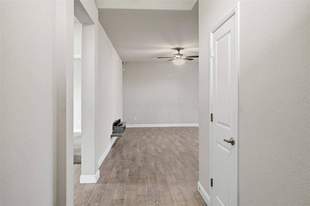 2513 Foules Drive, Glenn Heights, TX 75154 Hardwood-style flooring throughout, ceiling fan with integrated lighting, and a white paneled door with brushed nickel hardware