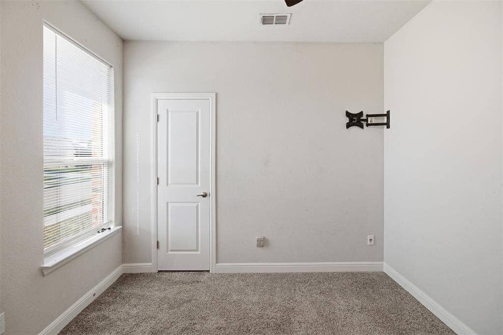 2513 Foules Drive, Glenn Heights, TX 75154 Wall-mounted television bracket, carpet flooring, and a single paneled door