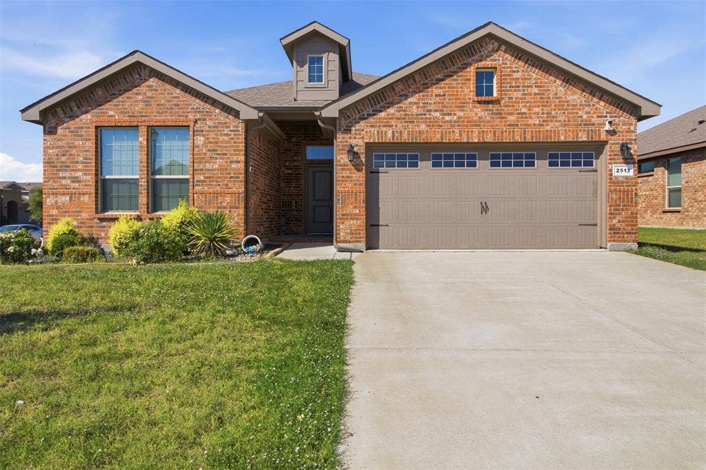 2513 Foules Drive, Glenn Heights, TX 75154 Brick facade with decorative shutters, integrated garage with transom windows, covered entryway, and front landscaping