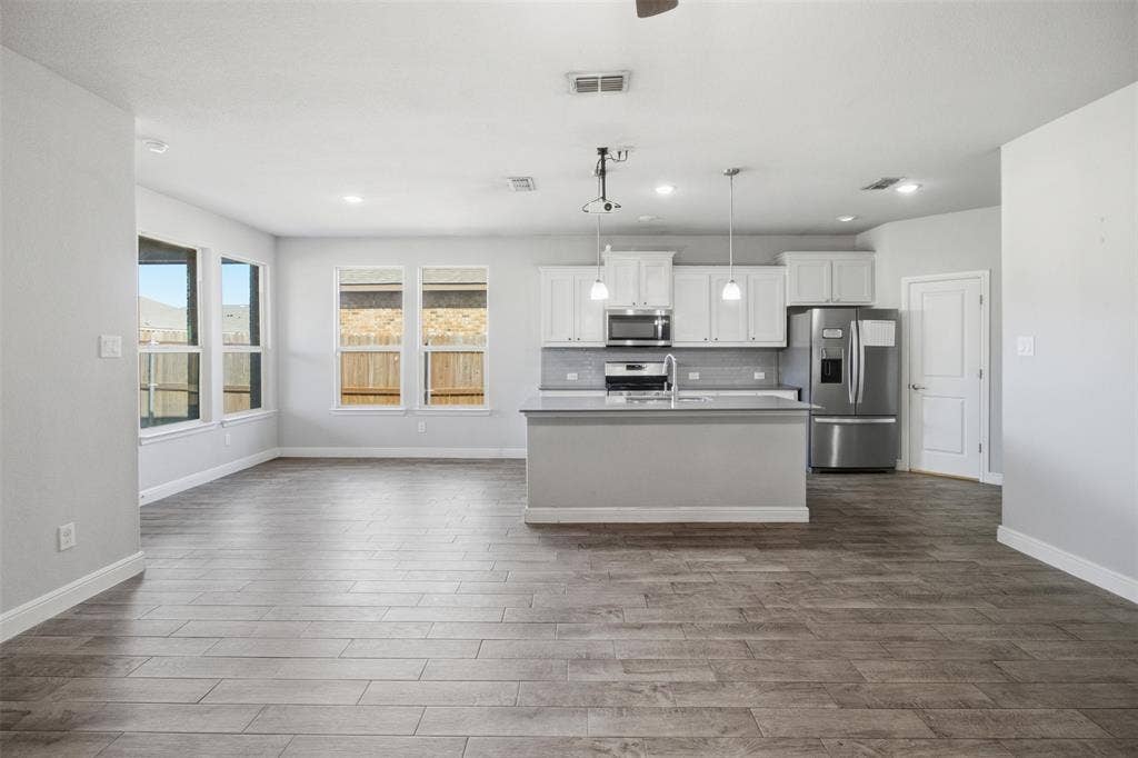 2513 Foules Drive, Glenn Heights, TX 75154 Spacious open-concept layout with wood-finish flooring, recessed lighting, and multiple windows