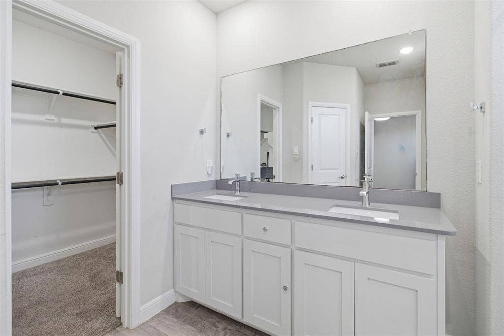 2513 Foules Drive, Glenn Heights, TX 75154 Dual sink vanity with white cabinetry, light gray countertop, and an expansive wall-mounted mirror
