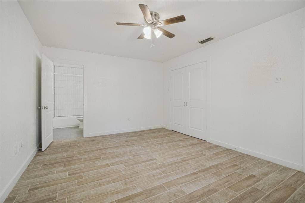 4420 Cochise Drive, Balch Springs, TX 75180 Spacious room featuring wood-finish tile flooring, ceiling fan with integrated lighting, and white bi-fold closet doors