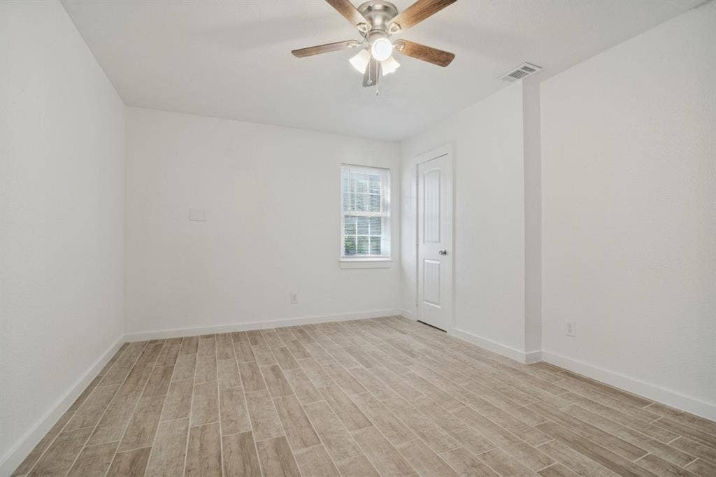 4420 Cochise Drive, Balch Springs, TX 75180 Wood-finish plank flooring, ceiling fan with integrated lighting, white interior door, and window with natural light