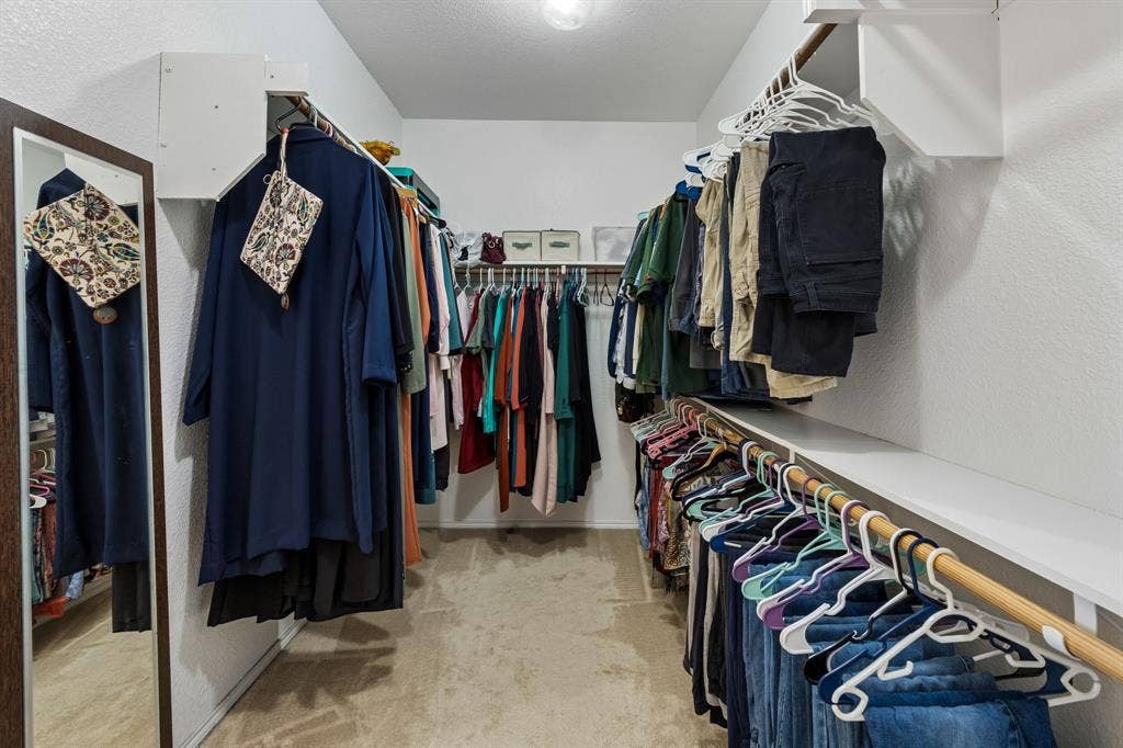 1501 Coyote Ridge Road, Wylie, TX 75098 Walk-in closet featuring built-in shelving, multiple hanging rods, and a full-length mirror