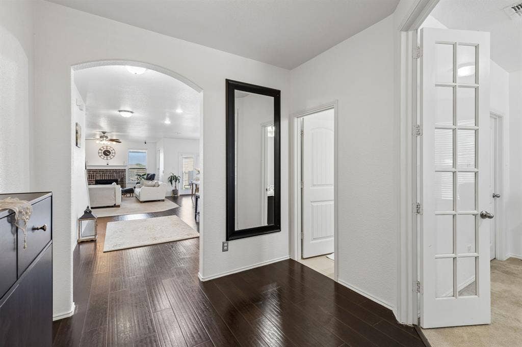 1501 Coyote Ridge Road, Wylie, TX 75098 Dark wood-finish flooring extending through an arched entryway