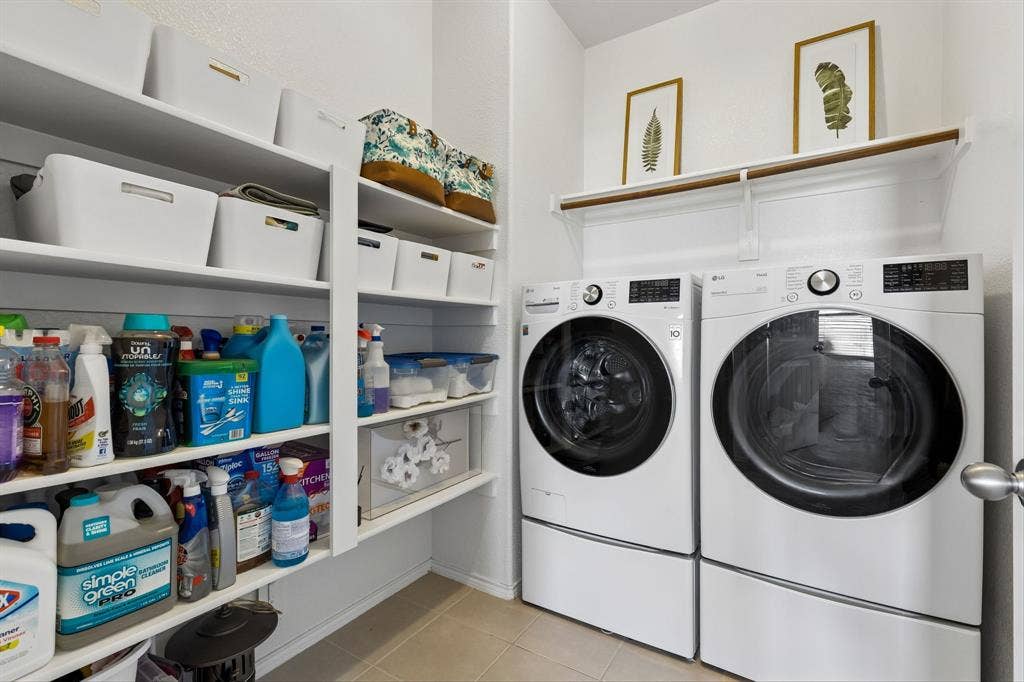 1501 Coyote Ridge Road, Wylie, TX 75098 Laundry area with built-in shelving, white front-loading appliances, and a hanging rod