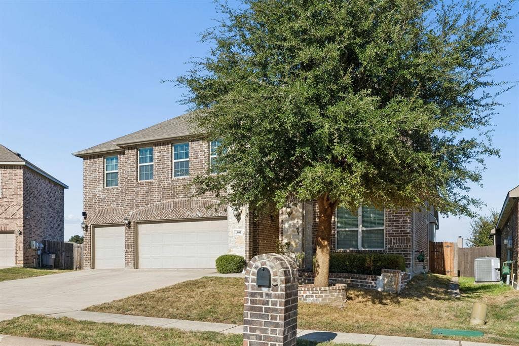 1501 Coyote Ridge Road, Wylie, TX 75098 Two-story brick exterior with a two-car garage and arched garage door accents